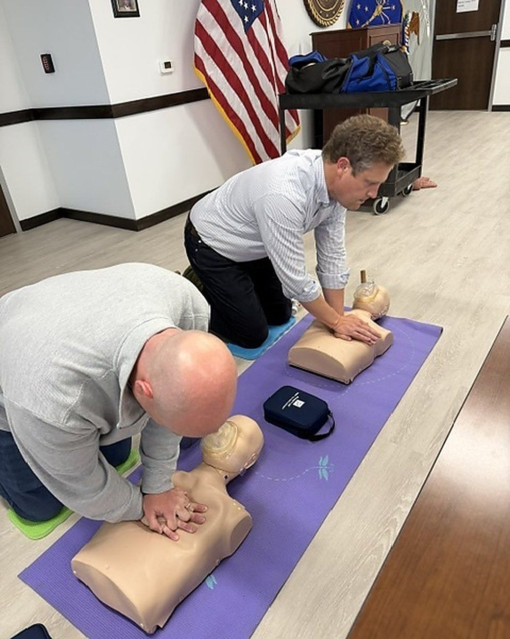 Colleagues practicing chest compressions side by side