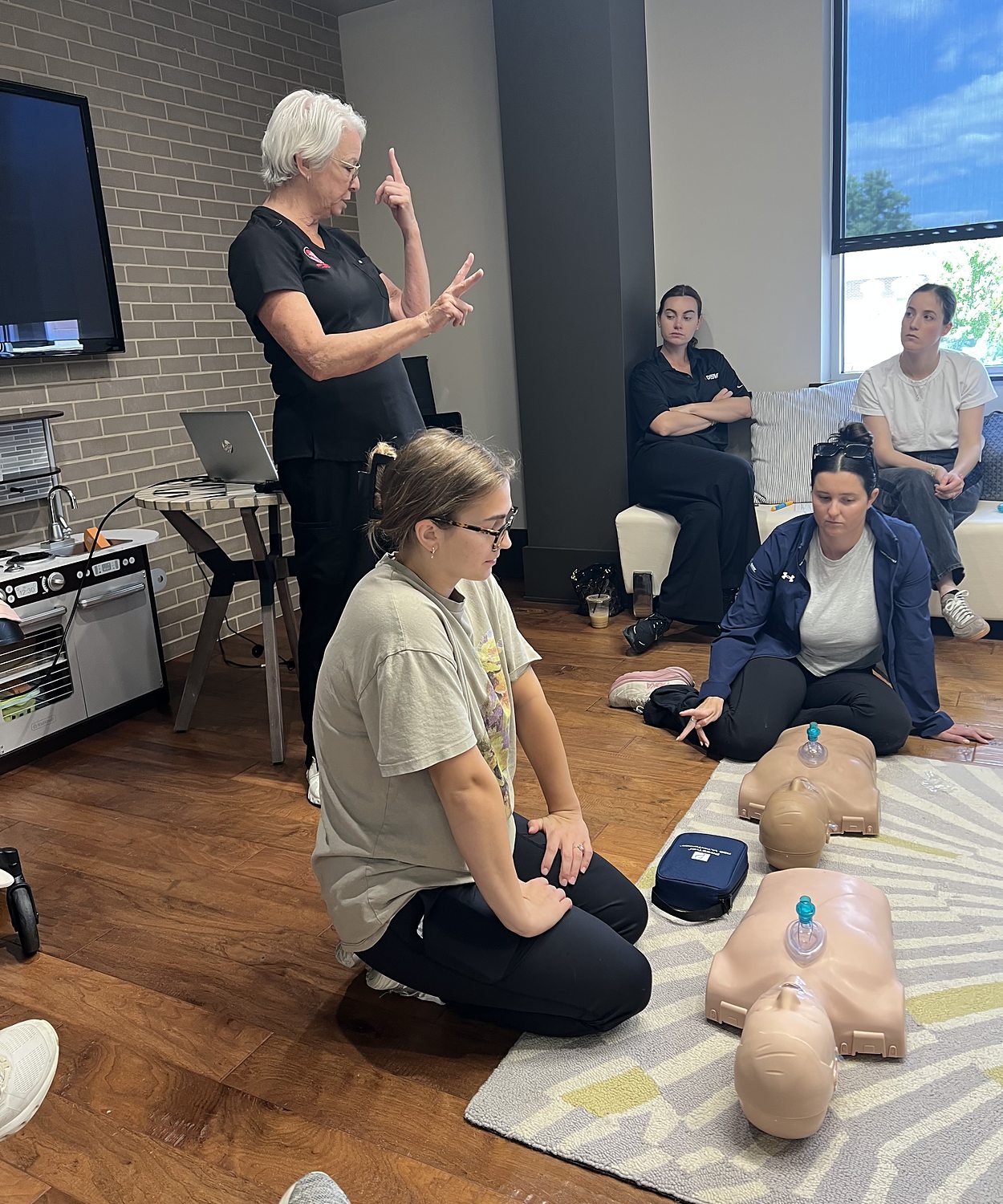 Pam Goldsberry, RN, counting out the compression rate while a group practices